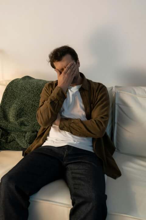 a man sad on his couch